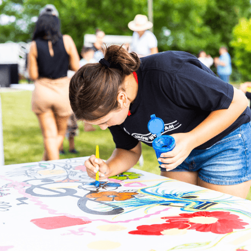 Photo of a woman coloring a mural laid flat on a table at Hello Inclusion