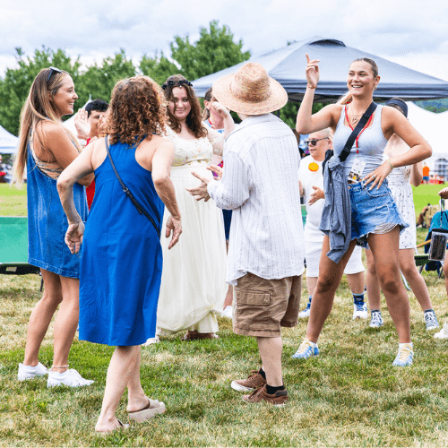 Photo of people dancing in a field during hello inclusion