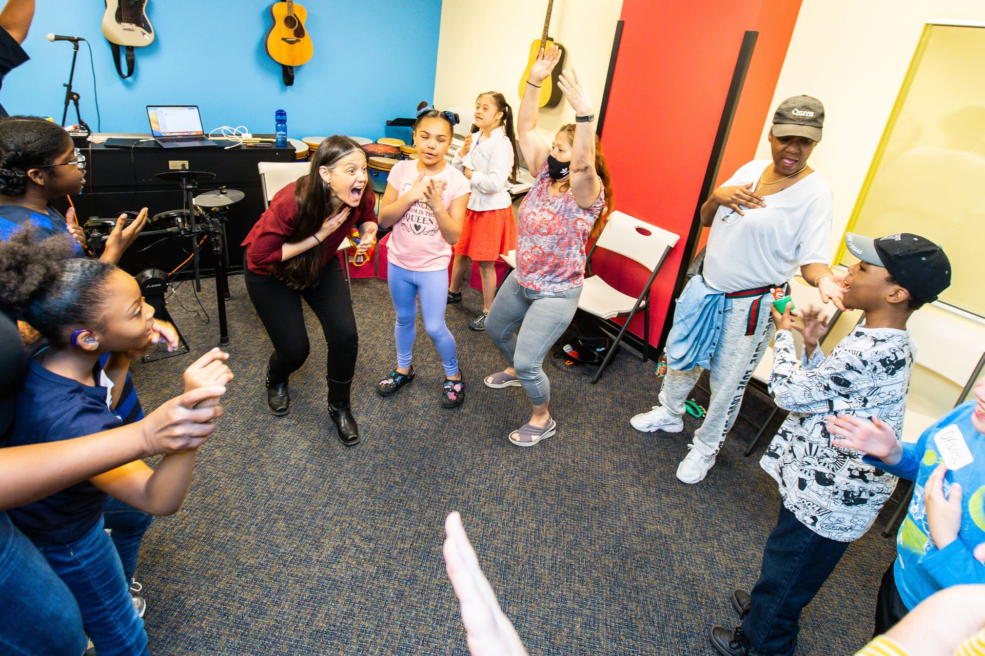 Image of Juliana dancing with members of a class, clapping their hands together
