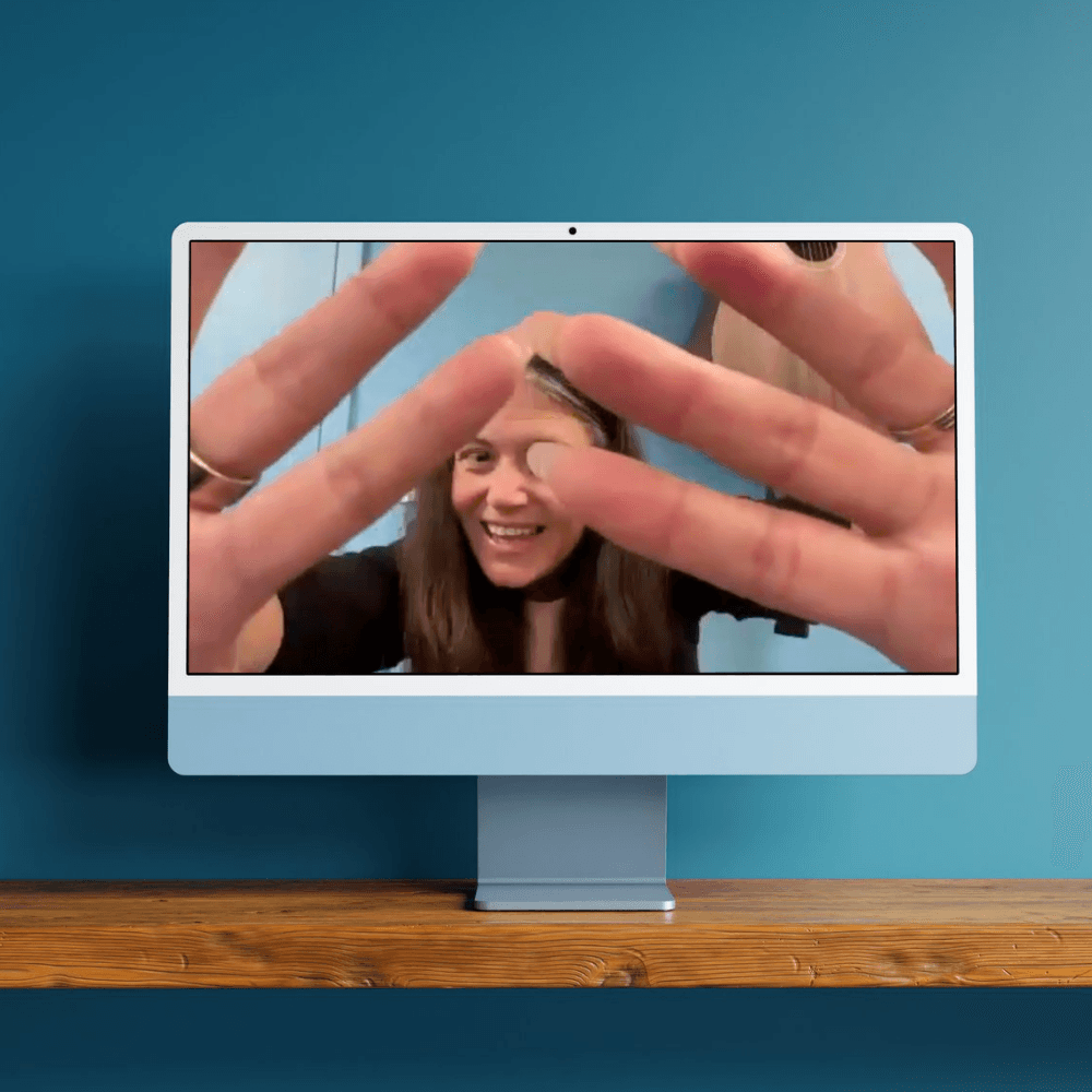 Photo of a computer on a desk, with instructor Juliana featured teaching on screen